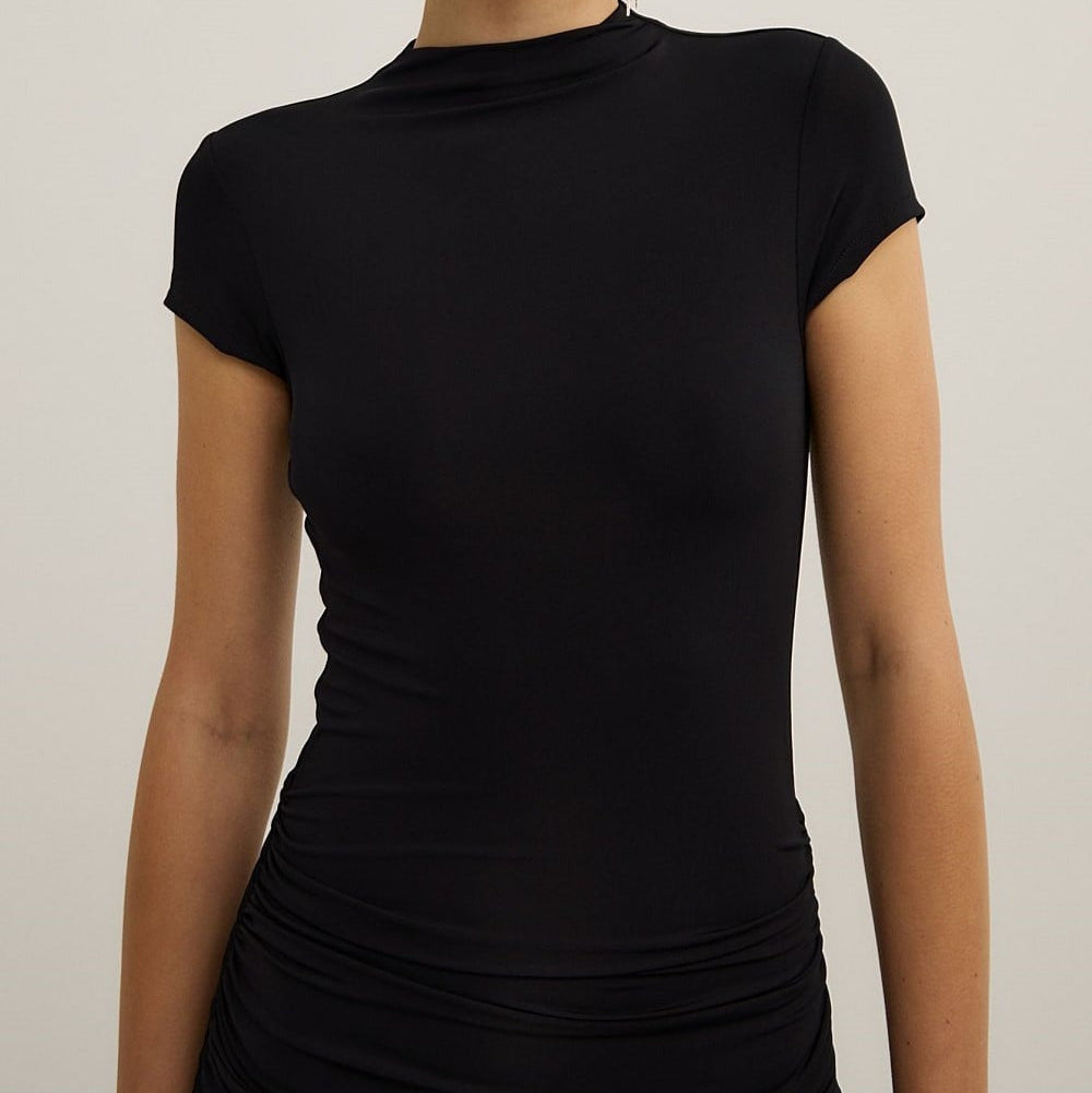 Woman wearing a black dress against a plain background