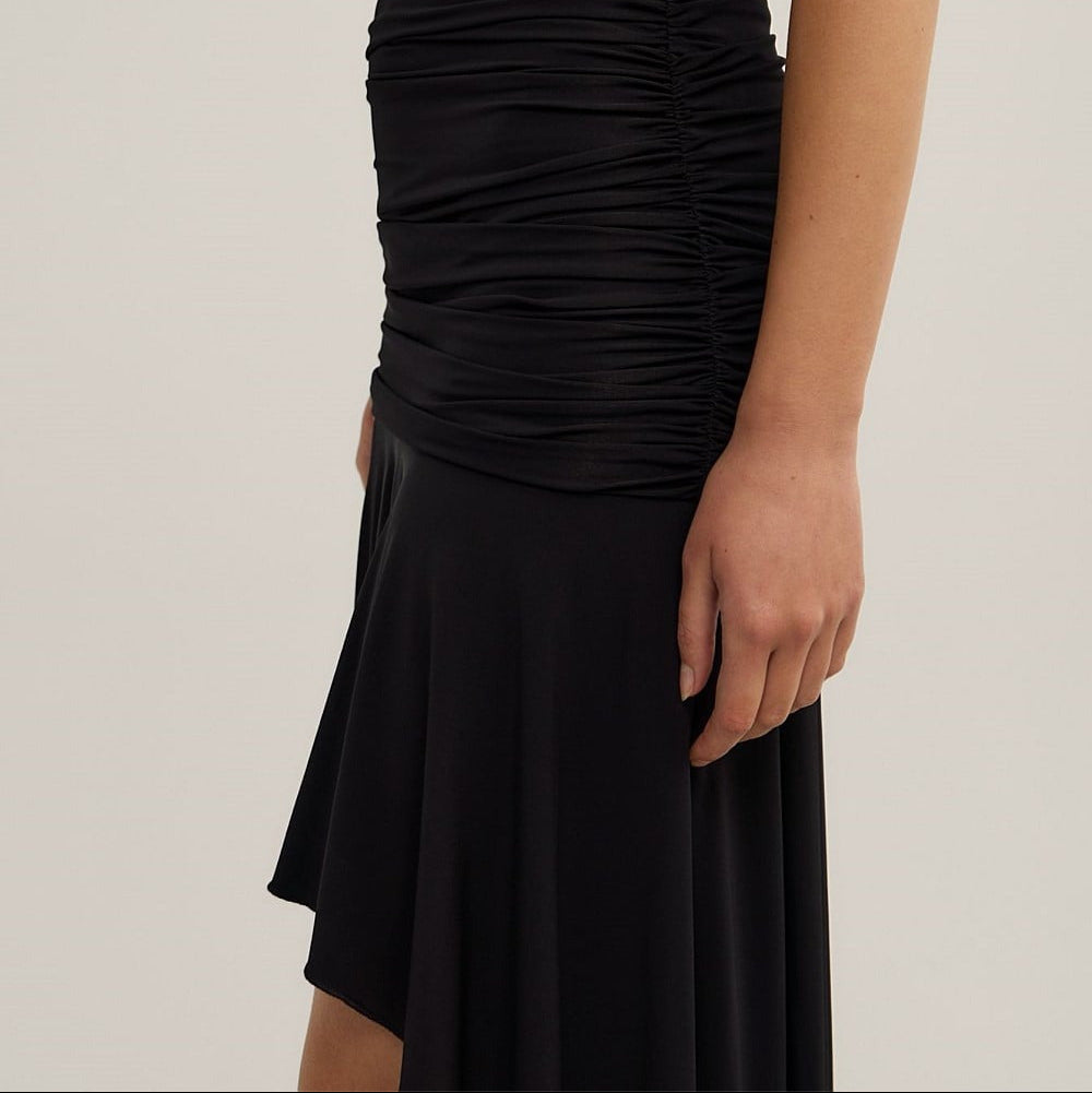Black ruched dress on a plain background